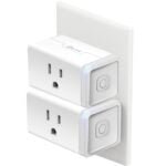 Kasa Smart Plug with a compact white design, plugged into a wall socket in a cozy home office, controlling a desk lamp. The smart plug highlights Wi-Fi connectivity, energy monitoring, and compatibility with Alexa and Google Assistant for voice-activated smart home control.