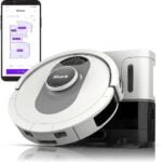 Shark AI Ultra Robot Vacuum with a sleek black and silver design, navigating around furniture on a hardwood floor. The vacuum features AI-driven smart mapping technology, powerful suction, and self-cleaning brushroll, highlighting its ability to provide deep cleaning with voice control compatibility.
