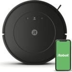 iRobot Roomba Vacuum with a sleek, round black design, moving across a hardwood floor in a modern living room. The robot vacuum is shown navigating around furniture, highlighting its smart mapping technology and powerful suction for hands-free home cleaning.