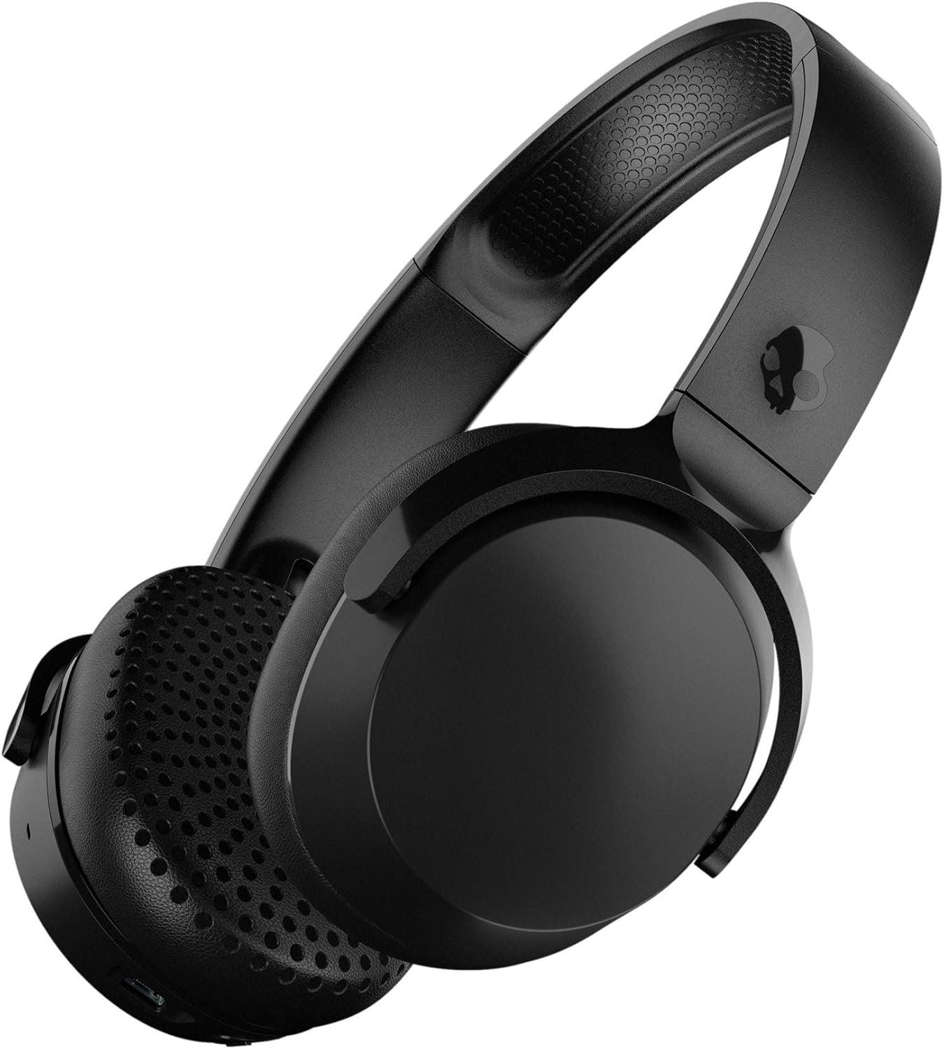 Skullcandy Riff Wireless headphones with a bold black design, featuring padded ear cups and an adjustable headband, resting on a vibrant desk setup. The headphones emphasize Bluetooth connectivity, rapid charging, and a lightweight build for all-day comfort and music streaming.